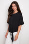 Side view of model wearing UP! Vegan Silk Tie Knot T-Shirt in Black with front tie-knot detail.