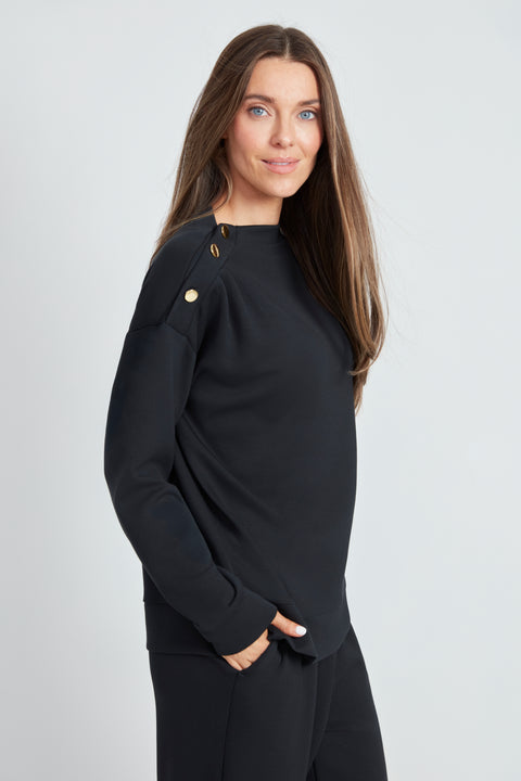 Side view of the Butter 3-Button Top in Black with gold button shoulder detail.