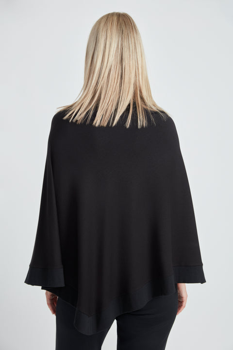 Woman wearing the Butter Cape in Black, back view.