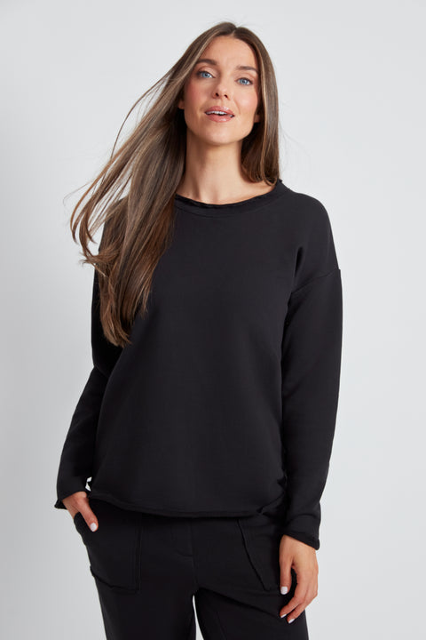 Woman wearing the French Terry Raw Edge Top in Black.