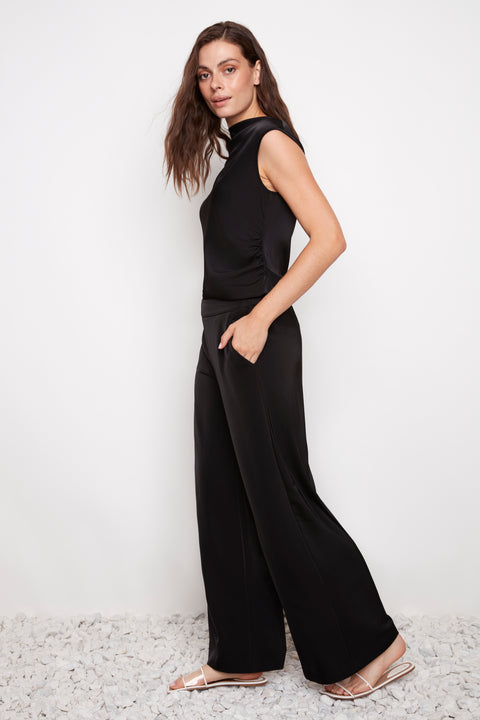 Side view of model wearing UP! Belize Satin Wide-Leg Full-Length Pant in Black with angled side pocket detail.