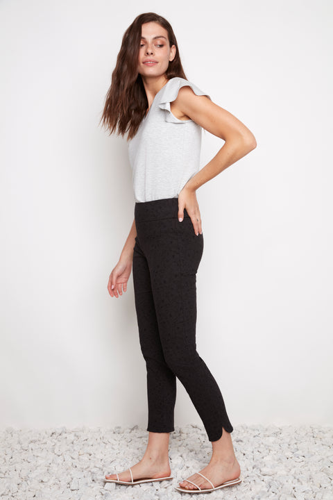 Side view of model wearing UP! Textured Techno Petal-Slit Ankle Pant in Black Loom with petal vent detail.