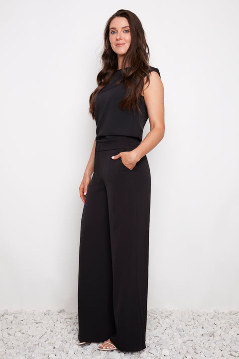 Side view of model wearing UP! Vegan Silk Wide-Leg Full-Length Pant in Black with tie-front ruched waist detail.