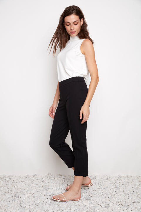 Side view of model wearing UP! Compression Slim Front-Cuff Crop Pant in Black with front-cuff detail.