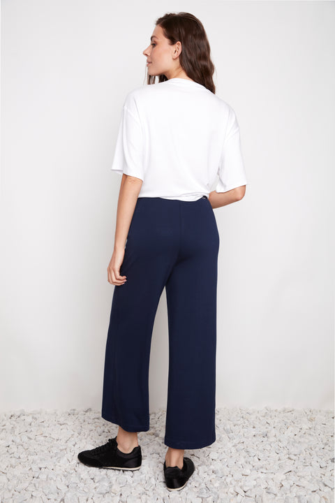 Back view of model wearing UP! Provence Wide Leg Pintuck Crop Pant in Harbor Navy.
