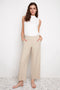 Model wearing UP! Techno Core Wide Leg Pant in Sand, front view.