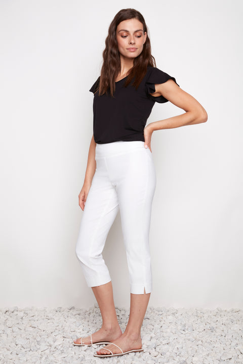 Side view of model wearing UP! Techno Core Capri Pant in White with side vent detail.