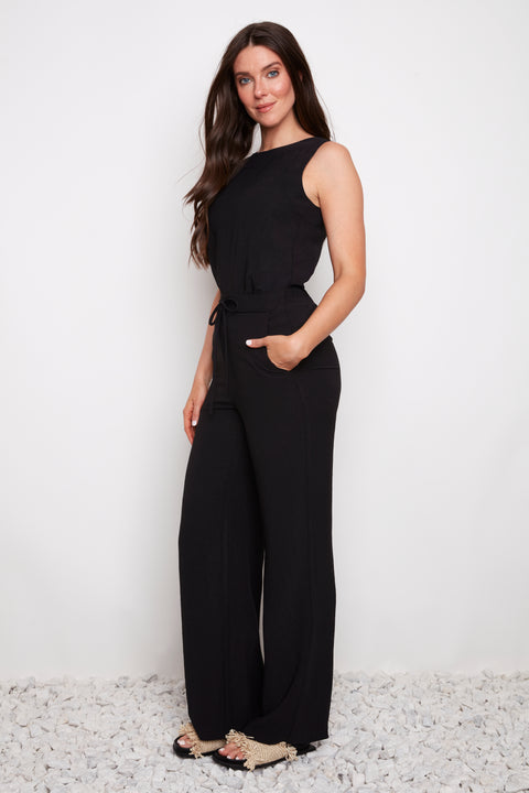 Side view of model wearing UP! Air Flow Wide Leg Pant in Black with tie-front ruched waist.