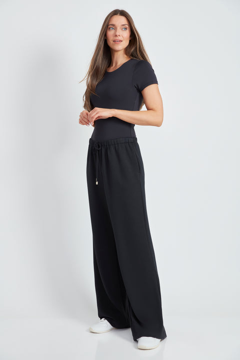 Woman wearing the Butter Wide Leg Pant in Black, side view.