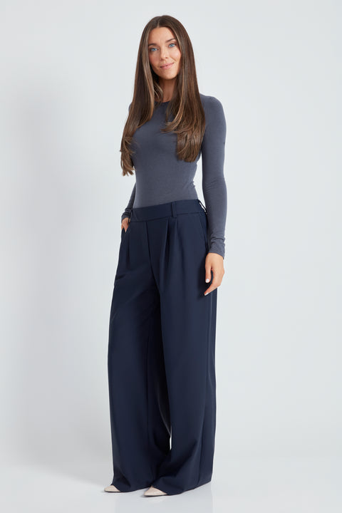 Woman wearing the Precision Ponte Wide Leg Pant in Navy, side view.