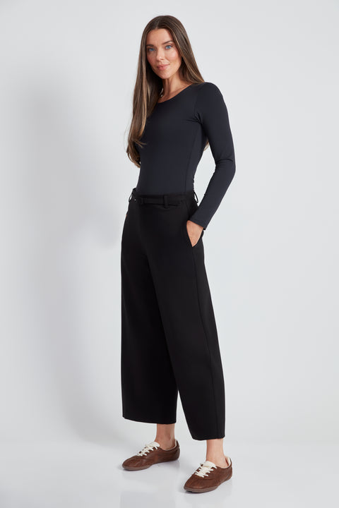 Woman wearing the Ponte Belted Gaucho Pant in Black, side view.
