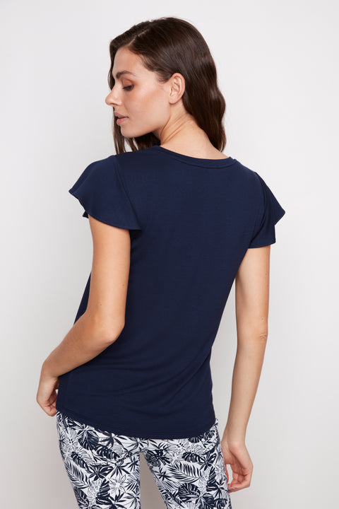 Back view of model wearing UP! Provence V-Neck Ruffle Sleeve Top in Navy.