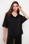 Model wearing UP! Belize Satin V-Neck Short Sleeve Top in Black, front view.