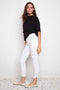 Side view of model wearing UP! Textured Techno Petal-Slit Ankle Pant in Whit Loom with petal vent detail.