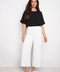 Model wearing UP! Vegan Silk Wide Leg Cropped Pant in Cream, front view.