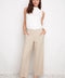 Model wearing UP! Techno Core Wide Leg Pant in Sand, front view.