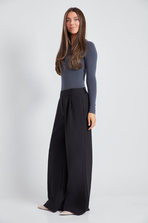 Woman wearing the Precision Ponte Wide Leg Pant in Black, side view.