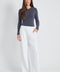 Woman wearing the Precision Ponte Wide Leg Pant in White.